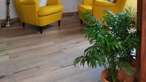 A room with two yellow armchairs, a small table with a vase of flowers, a floor lamp, and a fireplace. - La Casita de Ainhoa (Agüimes)  (Agüimes)