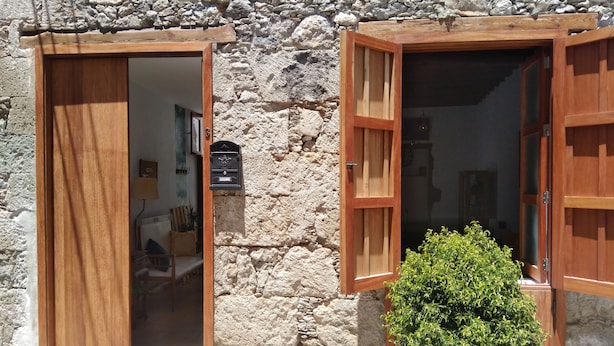 A stone building with wooden doors and windows, a mailbox, and a potted plant. - La Casita de Ainhoa (Agüimes)  (Agüimes)