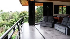 Un salón moderno con balcón que da a un jardín exuberante.