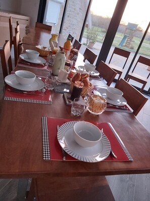 A dining table set with plates, bowls, and cutlery, with chairs around it. - Best Saintonge (Port-d'Envaux)