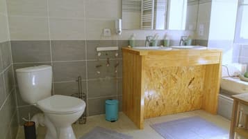 A bathroom with a toilet, sink, and mirror.