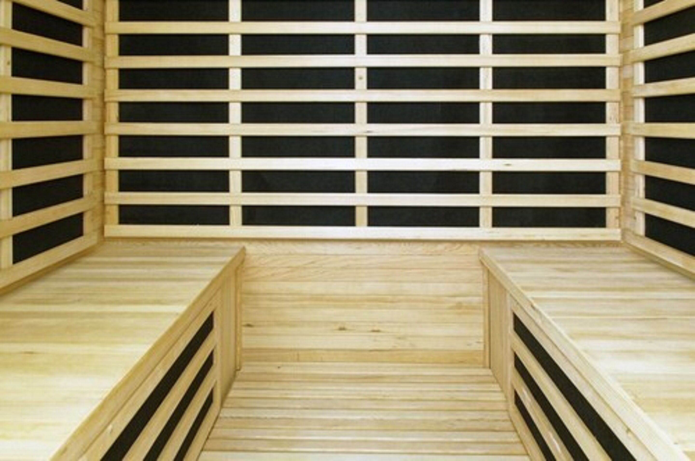Una sauna de madera con una hilera de bancos y suelo de madera.