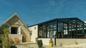 A modern building with a glass structure, a stone building to the left, and a clear sky. - Best Saintonge (Port-d'Envaux)