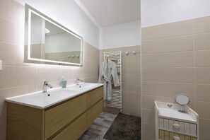 A modern bathroom with a double sink vanity, a large mirror, a towel rack, and a small vanity with a mirror. - Best Saintonge (Port-d'Envaux)