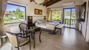 Une chambre à coucher comprenant un lit, une table de chevet, une chaise et donnant sur l’extérieur.