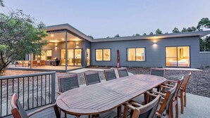 Una casa moderna con un patio, un comedor con mesa y sillas, y una cocina a la vista.