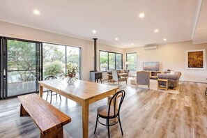 Un salón amplio con una mesa de madera, un banco y un sofá.