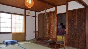 Ein traditioneller japanischer Raum mit Tatami-Böden, einem niedrigen Holztisch und einer Schiebetür.