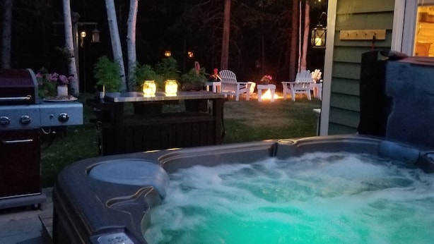 Un jacuzzi con terraza de madera y zona de estar al aire libre.