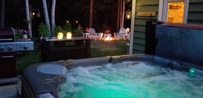A hot tub with a wooden deck and outdoor seating area.