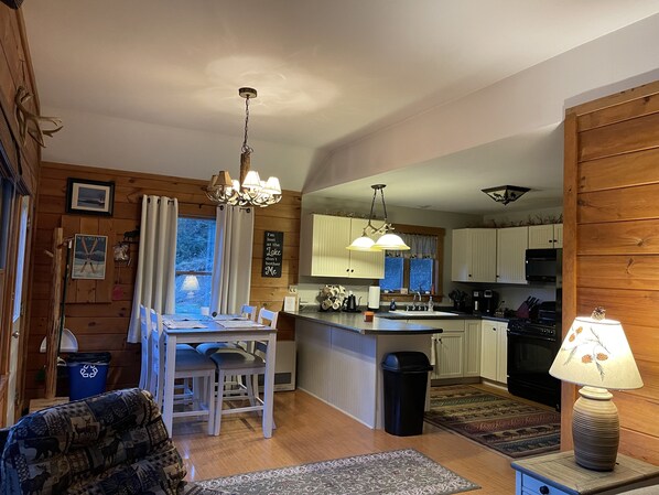 Interior acogedor de una cabaña con comedor, cocina y sala de estar.
