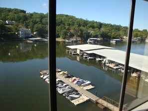 Stunning marina with docked boats and a covered boat launch area, surrounded by lush greenery and scenic hills.