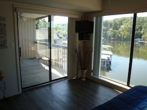 Enjoy the serene views from your balcony overlooking the water, featuring a comfortable chair and table.