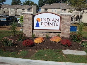 Indian Pointe Condominiums sign, set amidst a beautifully landscaped area.