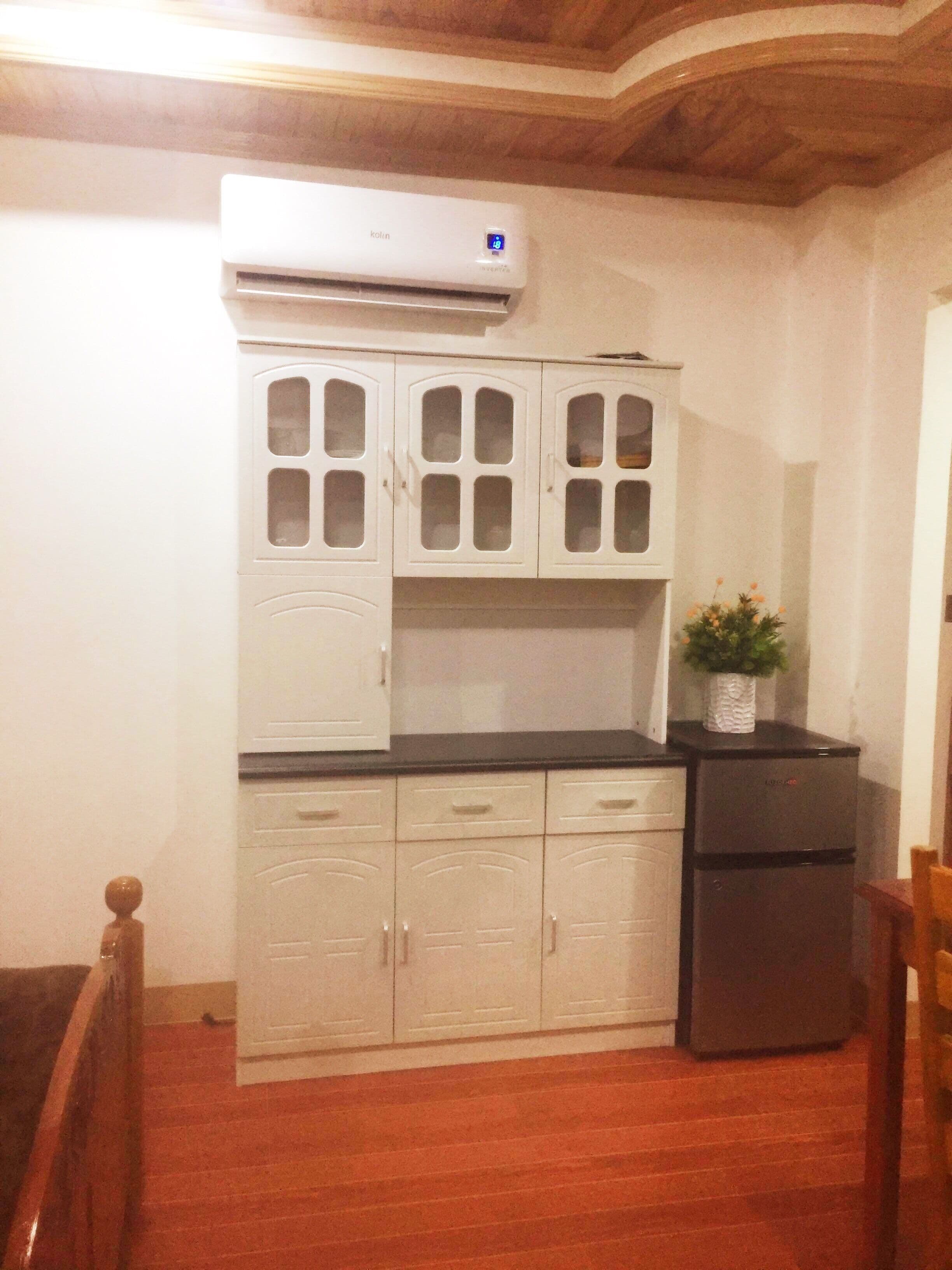 A kitchen with white cabinets, a built-in stove, and a refrigerator.