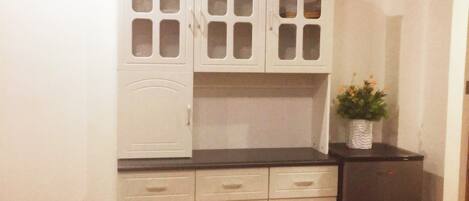 A kitchen with white cabinets, a built-in stove, and a refrigerator.