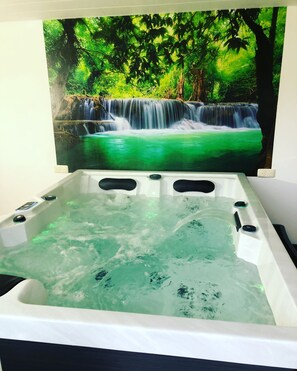 Un jacuzzi con un mural de cascada al fondo.