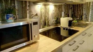 Une cuisine moderne équipée d’un four à micro-ondes, d’une machine à café et d’une cuisinière intégrée.