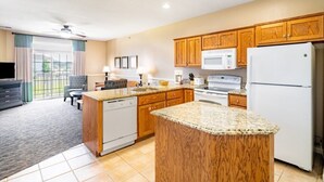 Una cocina moderna con armarios de madera, encimera de granito y lavavajillas integrado.