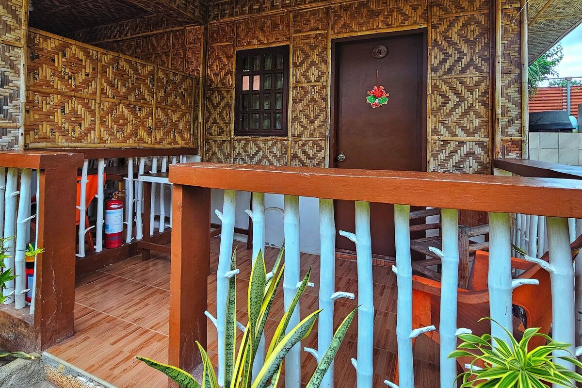 Une structure traditionnelle en bois, dotée d’un plafond orné de motifs et d’une porte en bois portant un numéro.