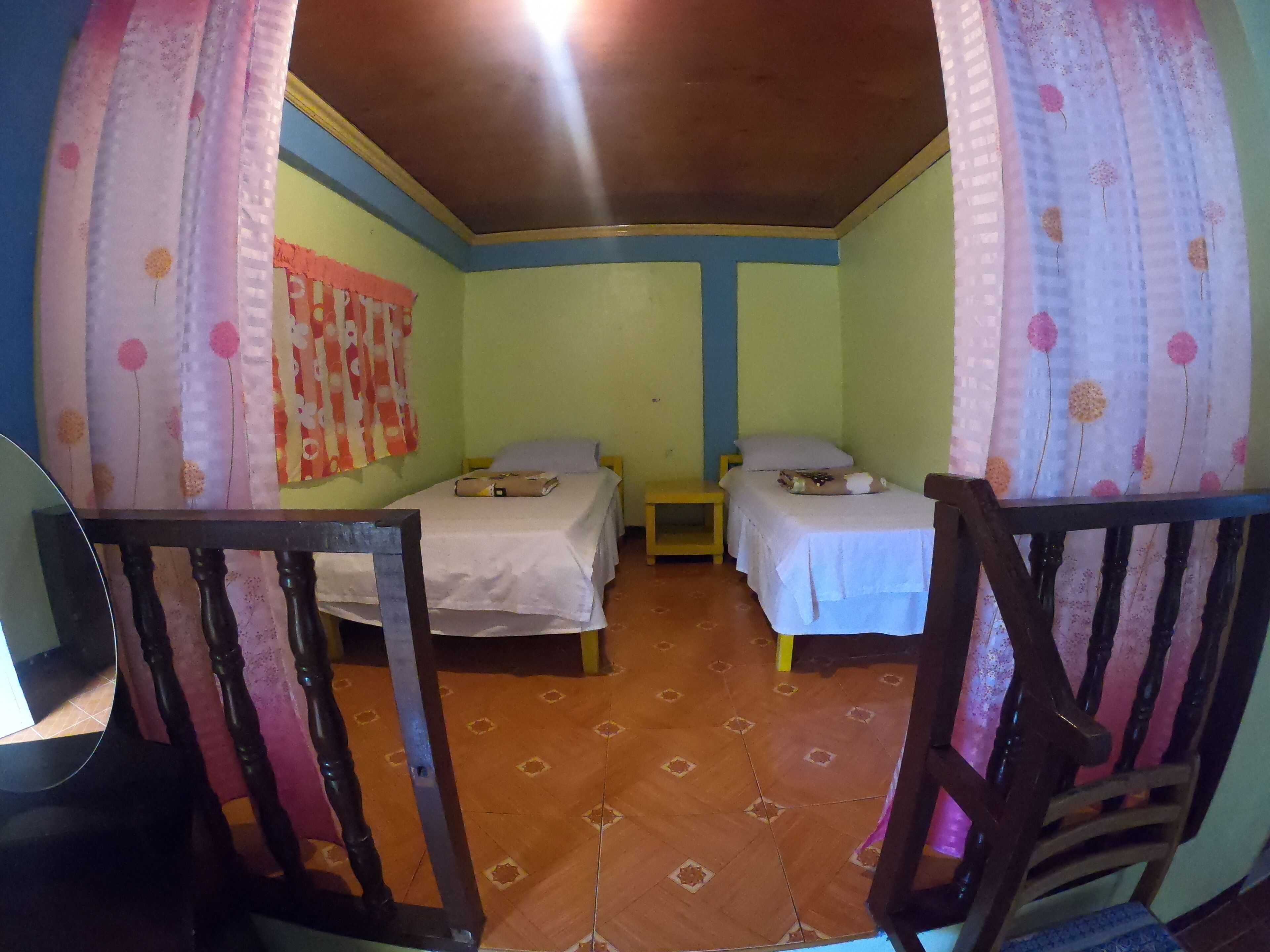 A room with two beds, a small table, and a chair.