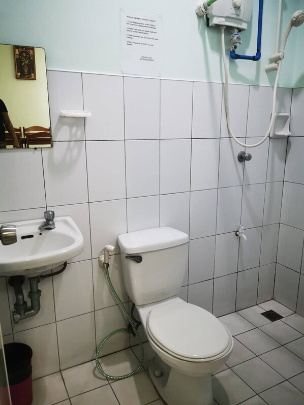 Un baño con inodoro, lavamanos y ducha.
