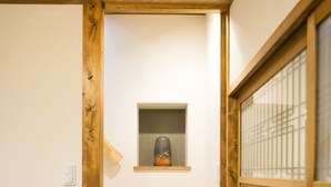 A staircase with wooden steps leading to a small shelf with a kettle. - Shichihonmatsu Machiya ICHI (Kyoto)