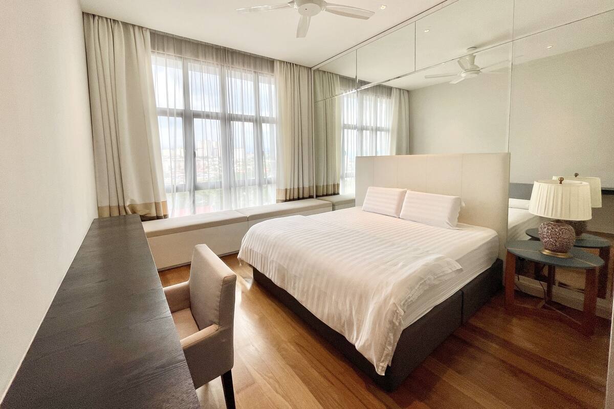 Une chambre d’hôtel moderne avec un grand lit, un bureau et une chaise.