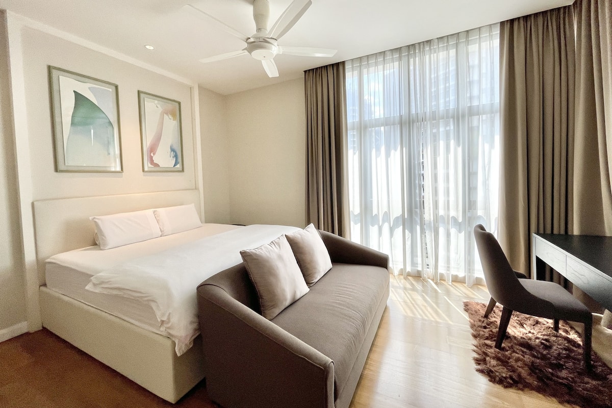 Une chambre d’hôtel moderne équipée d’un lit, d’un canapé, d’un bureau et d’une chaise.