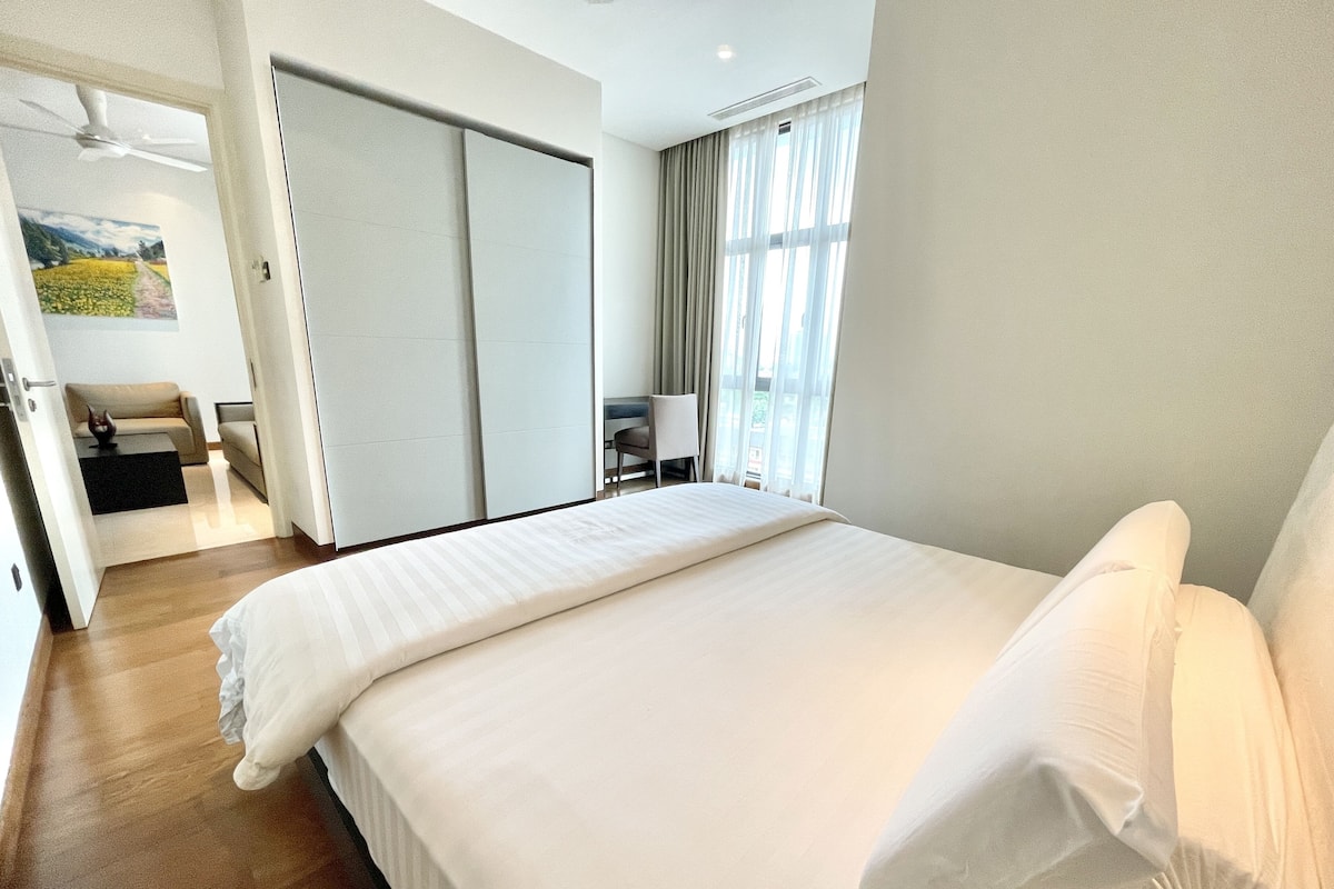 Une chambre d’hôtel avec un grand lit, un bureau, une chaise et une armoire.