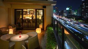 A balcony with wicker furniture and a bar area. - Hotel Mvsa (Taipei)