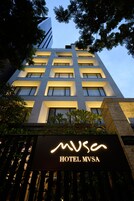 Een hotelgebouw met een modern ontwerp, meerdere verdiepingen en een opvallend bord met Hotel MVSA.