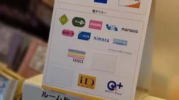 Eine Auswahl verschiedener Kreditkarten und ein QR-Code auf einem Präsentationsständer.