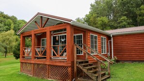 A wooden cabin with a porch, a staircase, and a view of a forested area. - Secluded Rustic Cabin (Cashton)