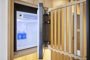A modern kitchen with a built-in refrigerator, wooden cabinets, and a stainless steel sink.