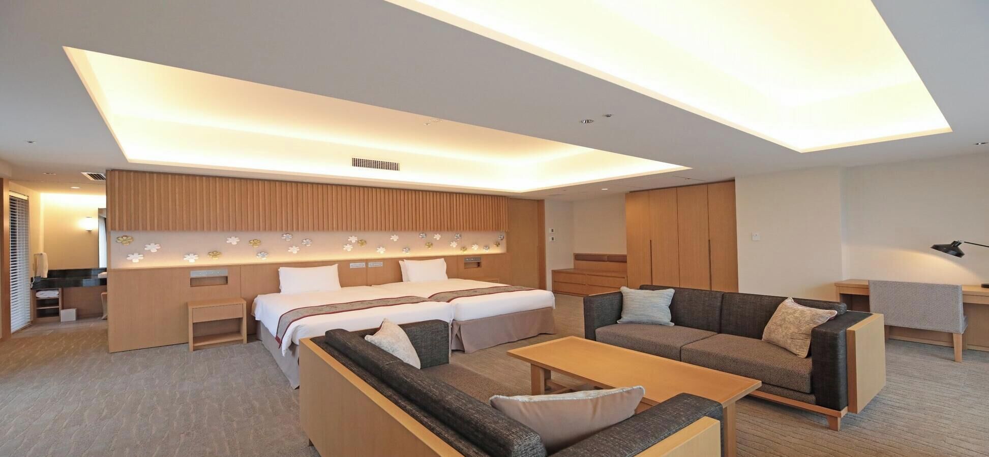 Una habitación de hotel moderna con cama, sofá y escritorio.