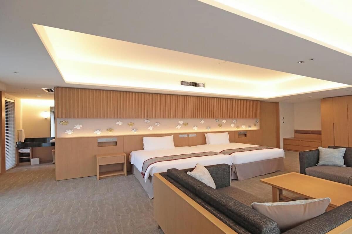 Una habitación de hotel moderna con cama, sofá y escritorio.