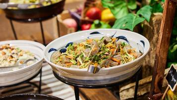 Un comedor con varios platos, incluyendo un tazón de vegetales salteados con carne y otro con un plato amarillo.