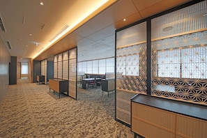 A modern hotel lobby with a carpeted floor, wooden partitions, and a reception desk.