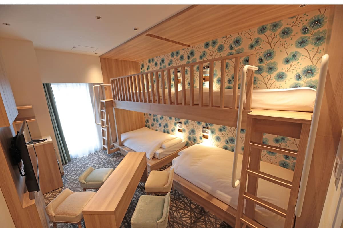 A bunk room with two beds, a desk, and a chair.
