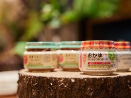 A row of jars labeled "Rice Porridge with Bonito Flakes" on a wooden surface.