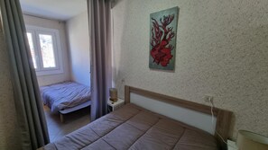 A bedroom with a bed, a bedside table, a lamp, and a window. - GRANDALLA  31 -1 apt 3 pers-Pas de la Casa- pie piste-006160 (PAS DE LA CASA)