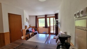 Una stanza accogliente con un tavolo da pranzo in legno, un divano e una TV.