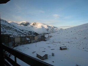 A snow-covered mountainous area with buildings and a clear sky.