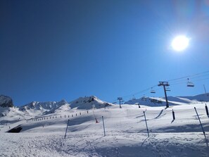 A snow-covered ski slope with a clear blue sky and a bright sun. - TETRAS 504-apt duplex-2 hab- 6pers-Pas de la Casa-005810 (PAS DE LA CASA)