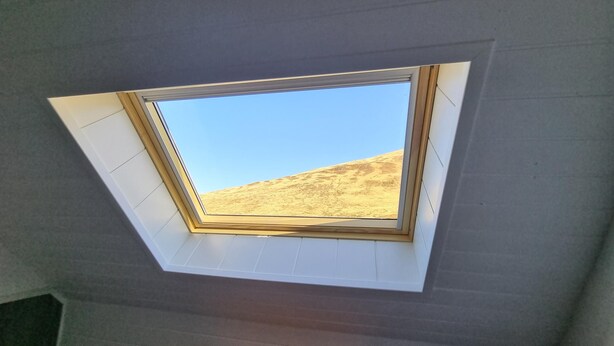 A skylight with a view of a barren landscape.