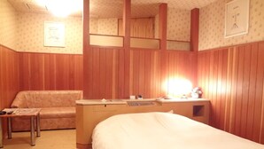 Una habitación de hotel con cama, escritorio, silla y una mesita.