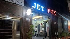 Entrada de un hotel con un letrero que dice "JET FOX" y otro que dice "RESIDENCY".