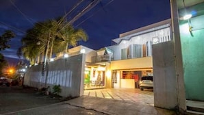 A modern two-story building with a balcony, a garage, and a well-lit entrance. - U Feel Home (Cebu City)