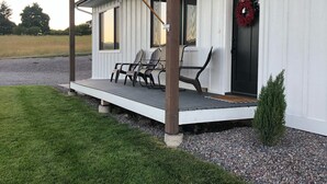 Ett hus med en veranda, en flagga och en krans på dörren.